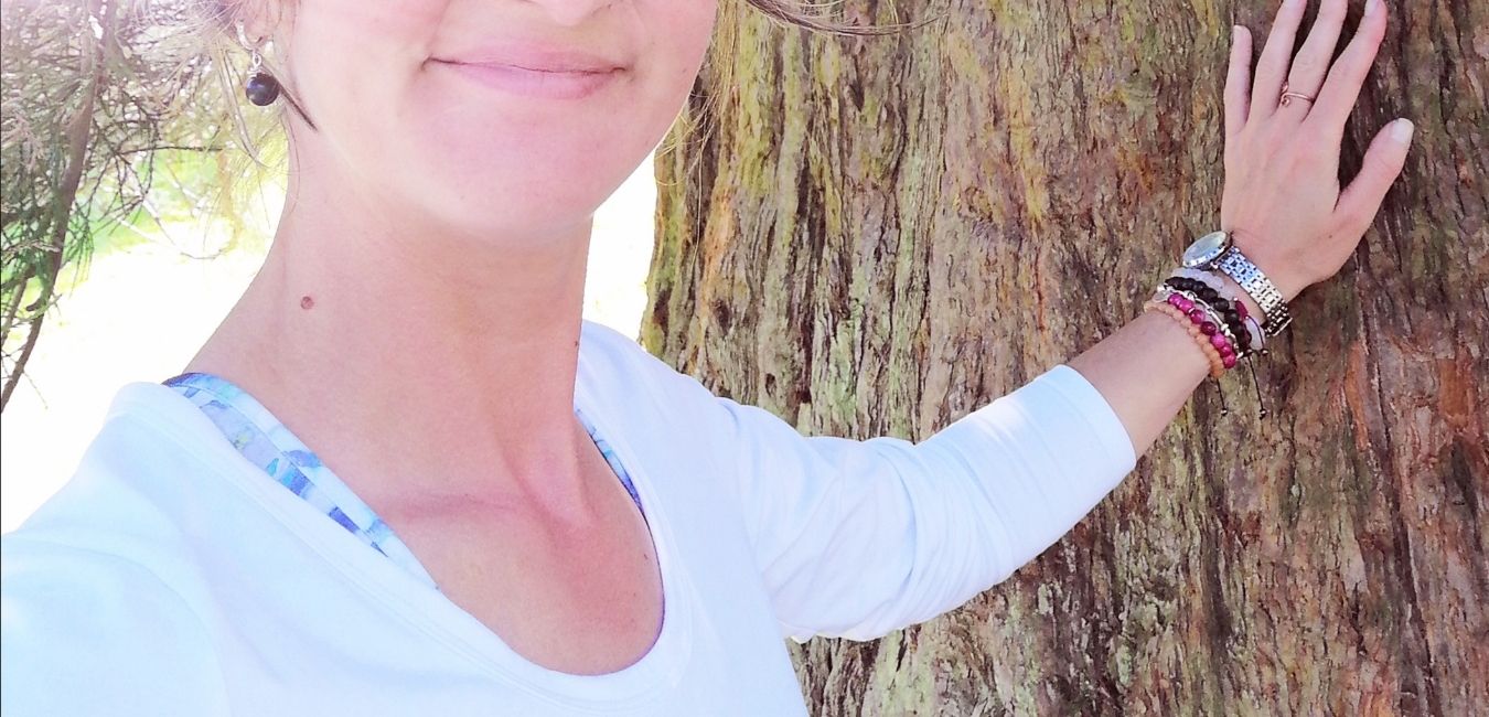 Dlon dotykajaca drzewa z bransoletkami z kamieni naturalnych