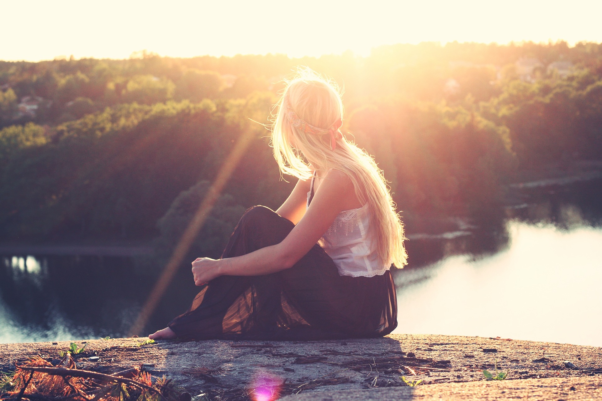 Girl sitting on a rock in the sunshine